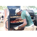 Cutting Edge Landscape &amp; Nursery man wearing hat preparing BBQ at the Spring Family Picnic event in Jordan Park on March 26, 2024.