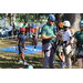 Pathfinder Outdoor Education person preparing children for tree climb at the Spring Family Picnic event in Jordan Park on March 26, 2024.