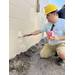 SPHA team member wearing yellow hat and painting house.