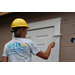 St. Petersburg Housing Authority (SPHA) woman wearing yellow hat outside painting Habitat for Humanity house.