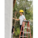 St. Petersburg Housing Authority (SPHA) woman outside on ladder painting Habitat for Humanity house.