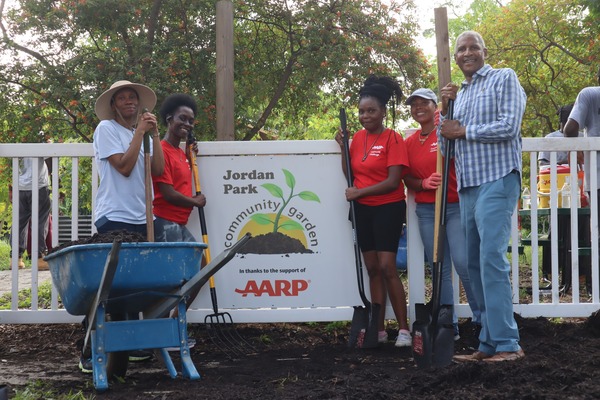 Five people unveiling the new Jordan Park Community Garden sign on August 8, 2024.