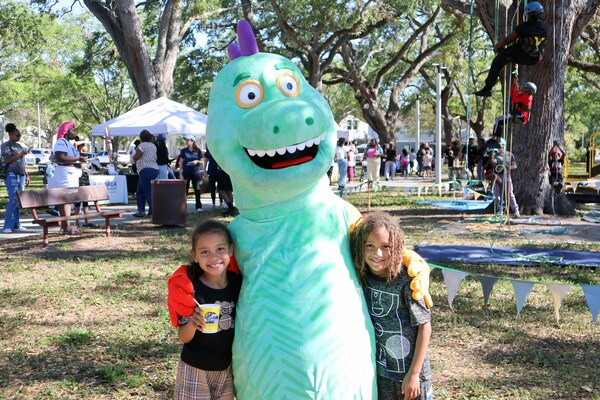 Two children with dinosaur mascot at Spring Family Picnic in Jordan Park.