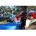 Two SPHA team members at blue table and a child at Spring Family Picnic in Jordan Park.