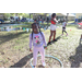 Child wearing pink outfit smiling and hula-hooping at Spring Family Picnic in Jordan Park.