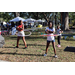 Youth hula-hooping with tents in the background at Spring Family Picnic in Jordan Park.