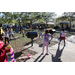 Youth hula-hooping at Spring Family Picnic with Jordan Park Apartments in background.