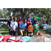  Group of people standing by table of backpacks at Back to School Event in Jordan Park 2025. 