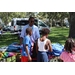  SPHA team member and children at backpack table at Back to School Event in Jordan Park 2025. 