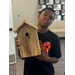  Student holding a wood birdhouse at Summer Construction Camp 2025. 