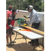  Student and teacher cutting wood outside at Summer Construction Camp 2025. 