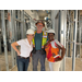  Two women and one man wearing hardhats. 