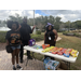  Three people standing by table with treats at Trunk or Treat event at Disston Place Apartments. 