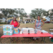  Two people at red table with food at the Very Merry Holiday Party in Jordan Park. 